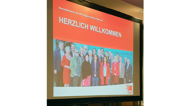 Foto einer Leinwand, darauf das Gruppenbild der Regionsfraktion und geschrieben: Haushaltsklausur der SPD-Regionsfraktion Hannover - Herzlich willkommen